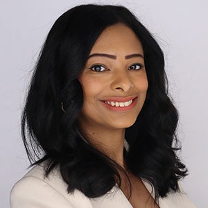 Portrait of woman with black wavy hair in white blazer