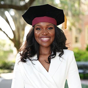 Portrait of woman wearing doctorate cap with gold tassle