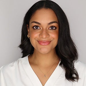 Portrait of woman with black hair in white v neck blouse
