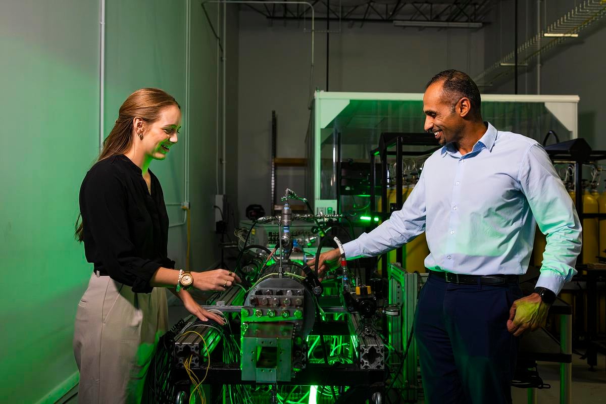 Two researchers working in a lab with green light