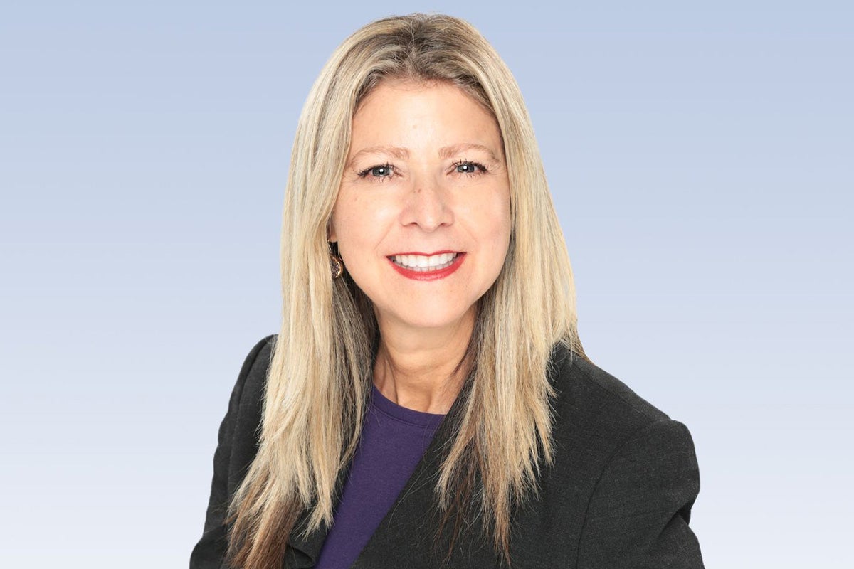 Portrait of blonde woman in black business jacket and deep purple shirt