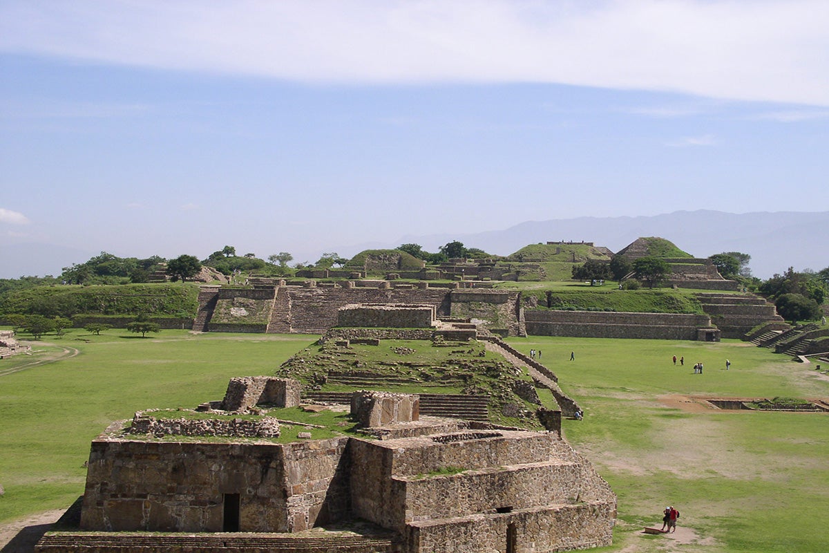 Stone ruins on green land with blue sky in the background