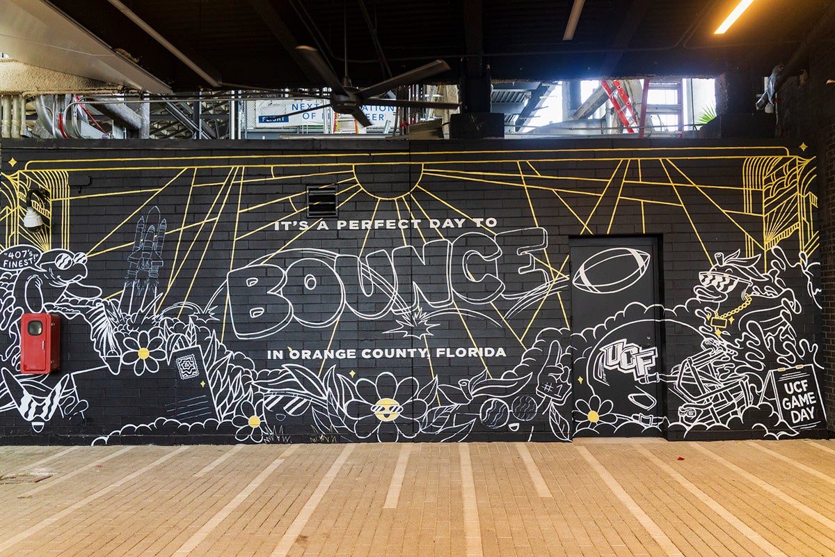 Chalkboard style mural with gold accents and text that reads "It's a great day to bounce in Orange County, Florida"