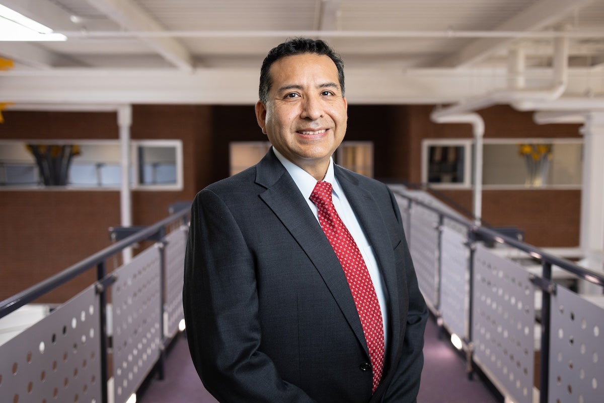 UCF Professor Ivan Garibay smiles for a photo while standing on an indoor walkway.