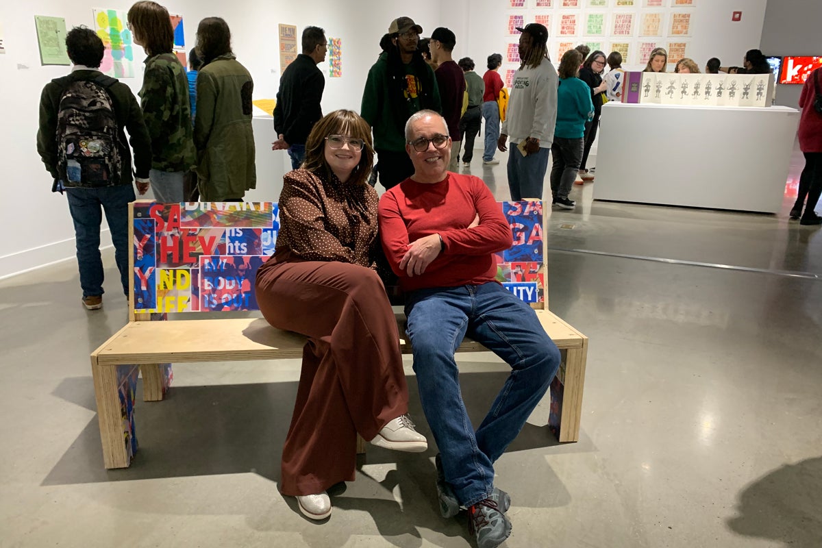 Two people posing for a photo in an art gallery