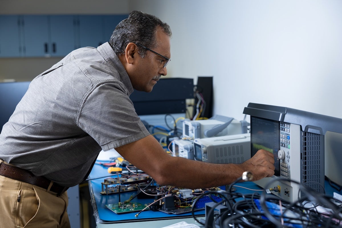 Anish Roshi Damodaran works at a computer monitor displaying technical information in his laboratory.