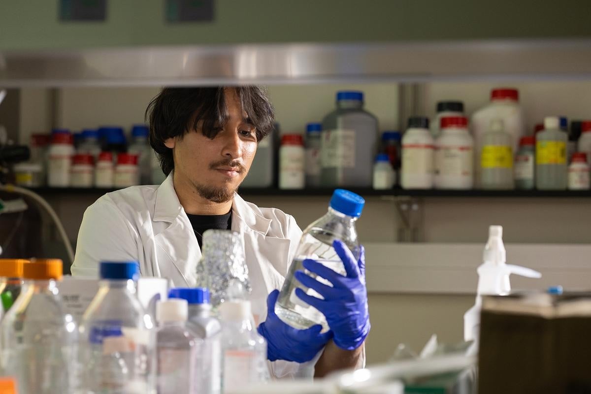 A person examining a bottle in a lab