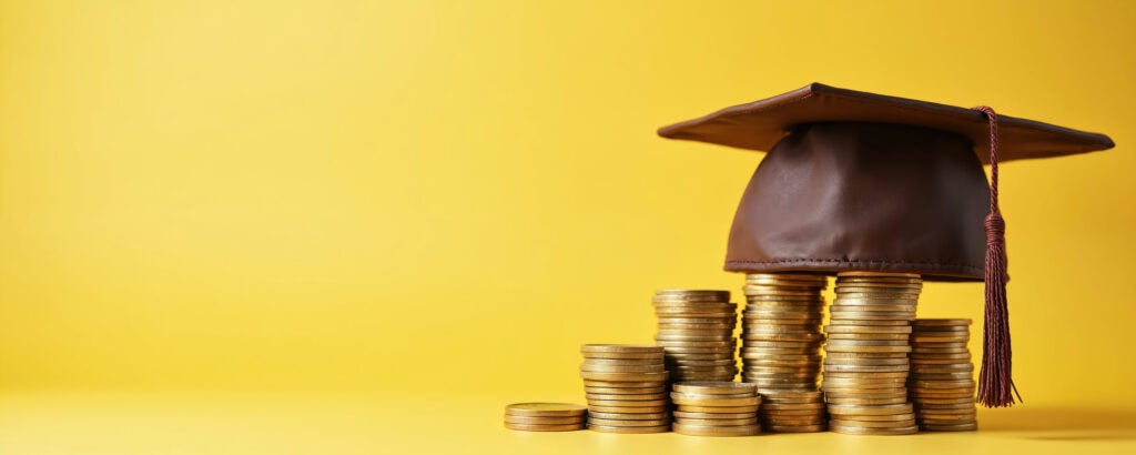 grad cap on top of a stack of coins