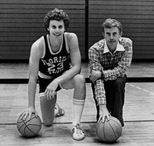 Photo of Bo and Torchey Clark kneeling with basketball on a basketball court.