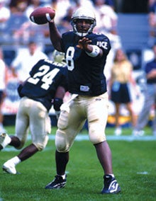 Photo of Daunte Culpepper with football on the football field.