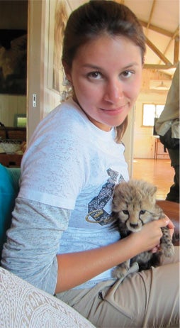 Student holding a baby cheetah
