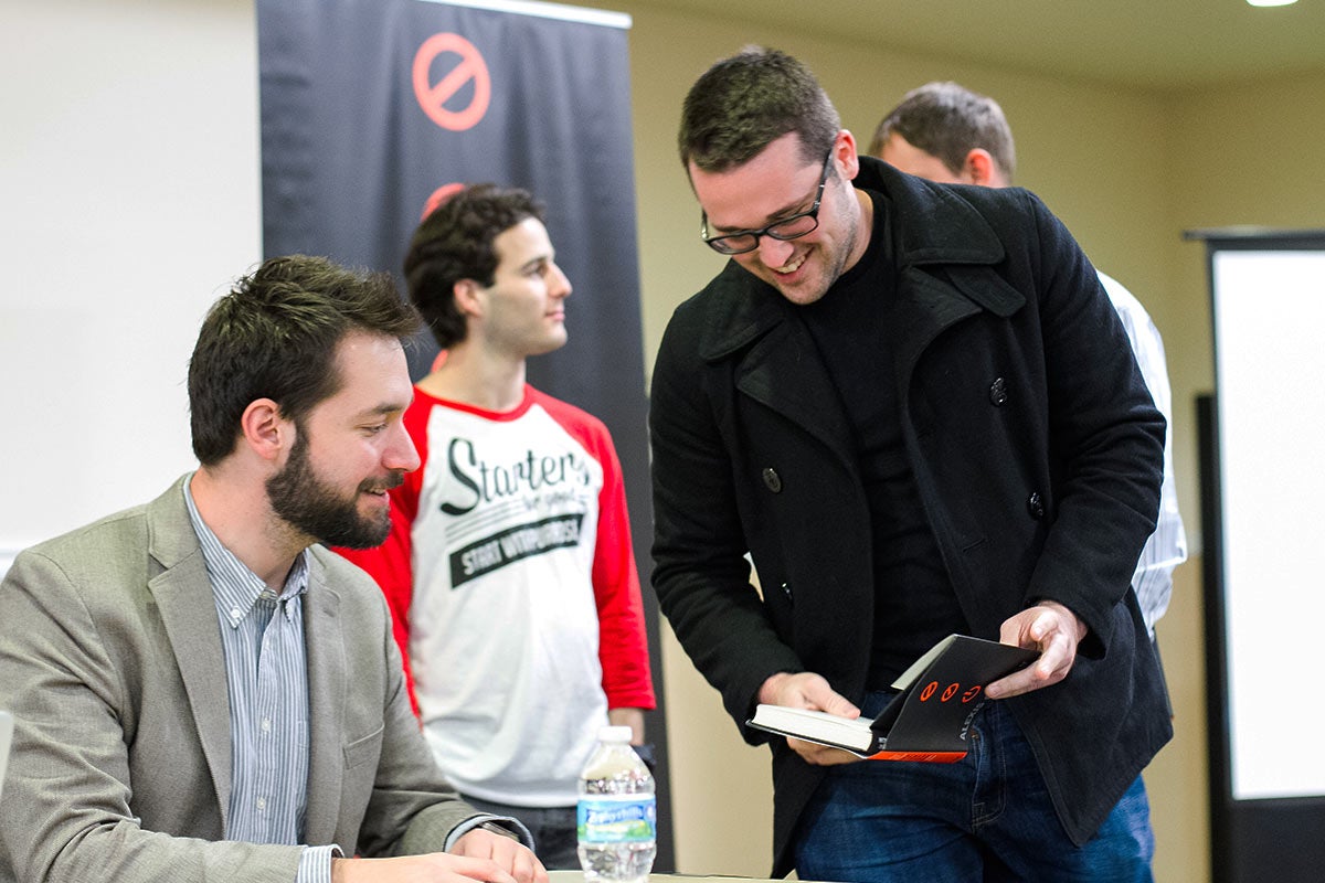Alexis Ohanian, co-founder of Reddit, autographs a book