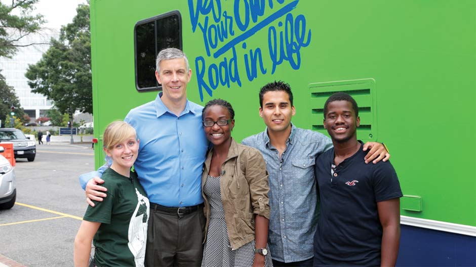 Four people posing for a photo with Arne Duncan, Secretary of Education