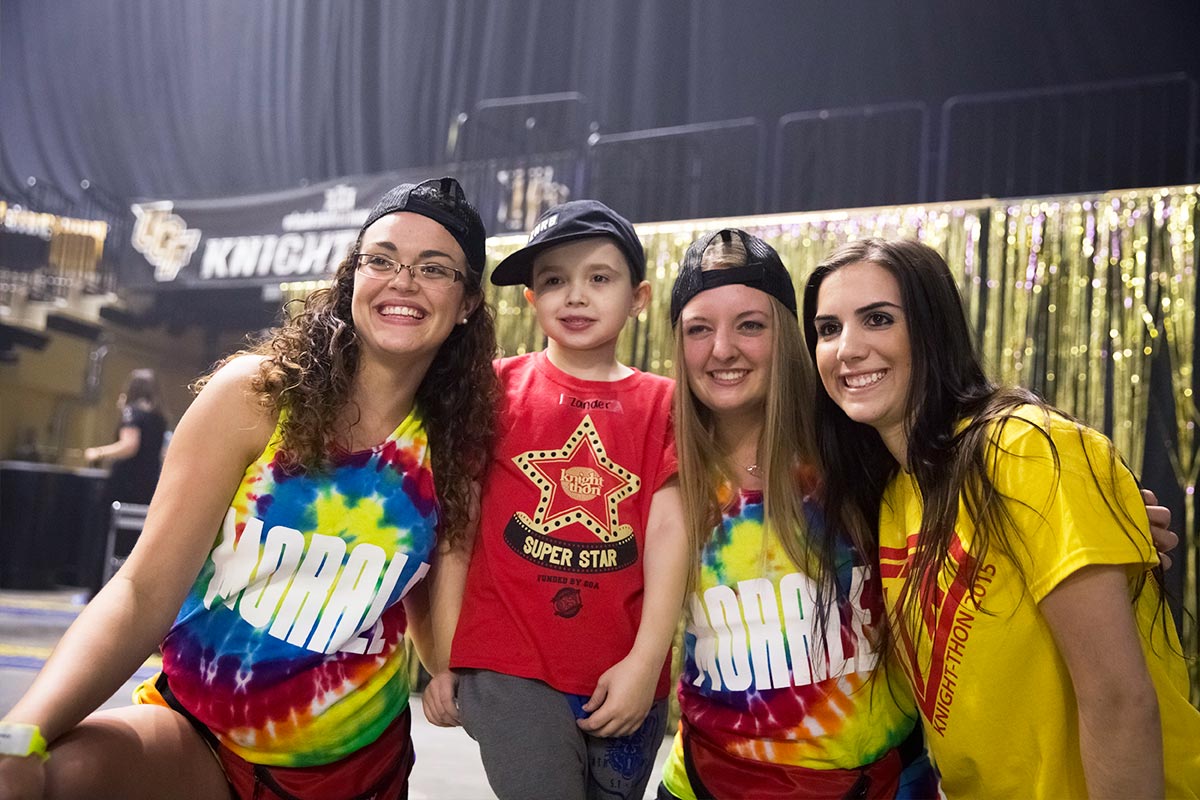 Kid posing with volunteers