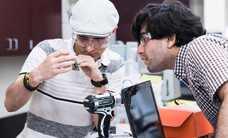 Two students working on an electronics project