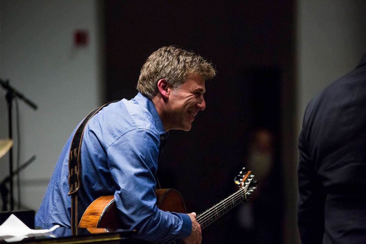 Guitarist Peter Bernstein laughs while holding a guitar.