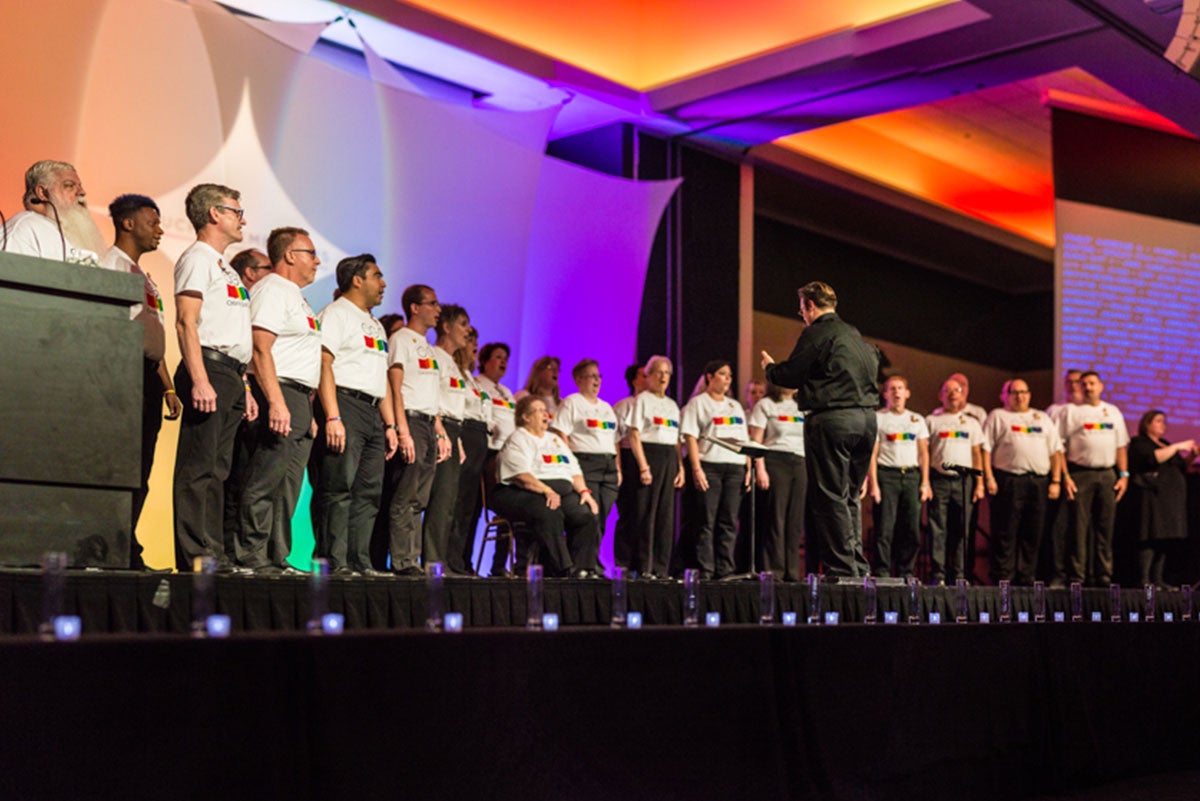 A group of people stand on a stage and sing.