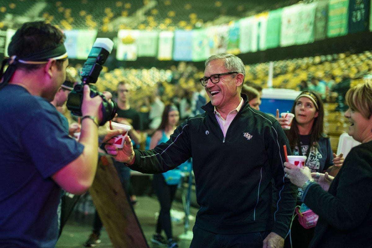 Dale Whittaker smiles as he grabs a smoothie and a photographer takes his photo.