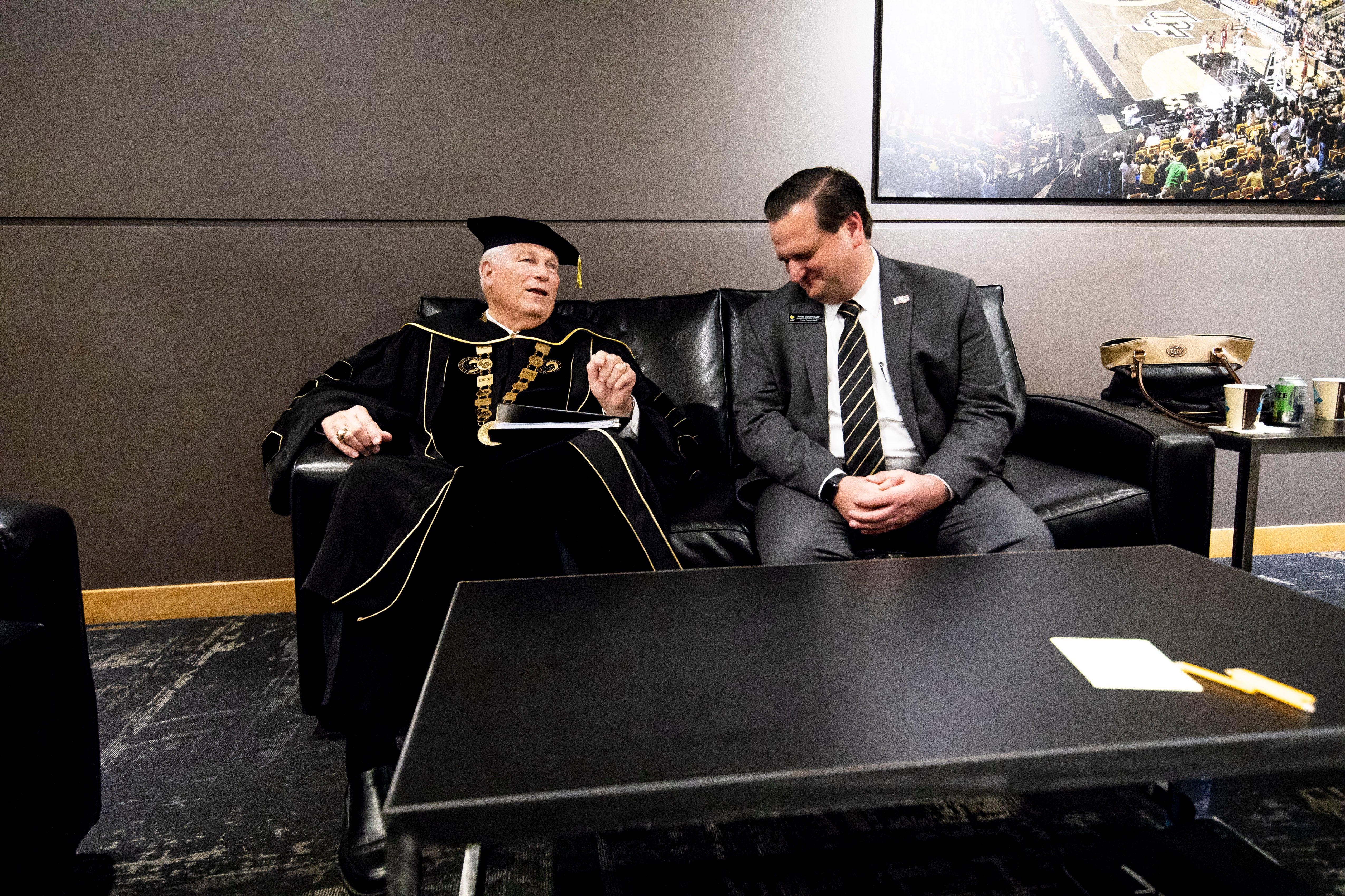 ohn C. Hitt sits with his personal security detail on a couch. ohn C. Hitt sits with his personal security detail on a couch.