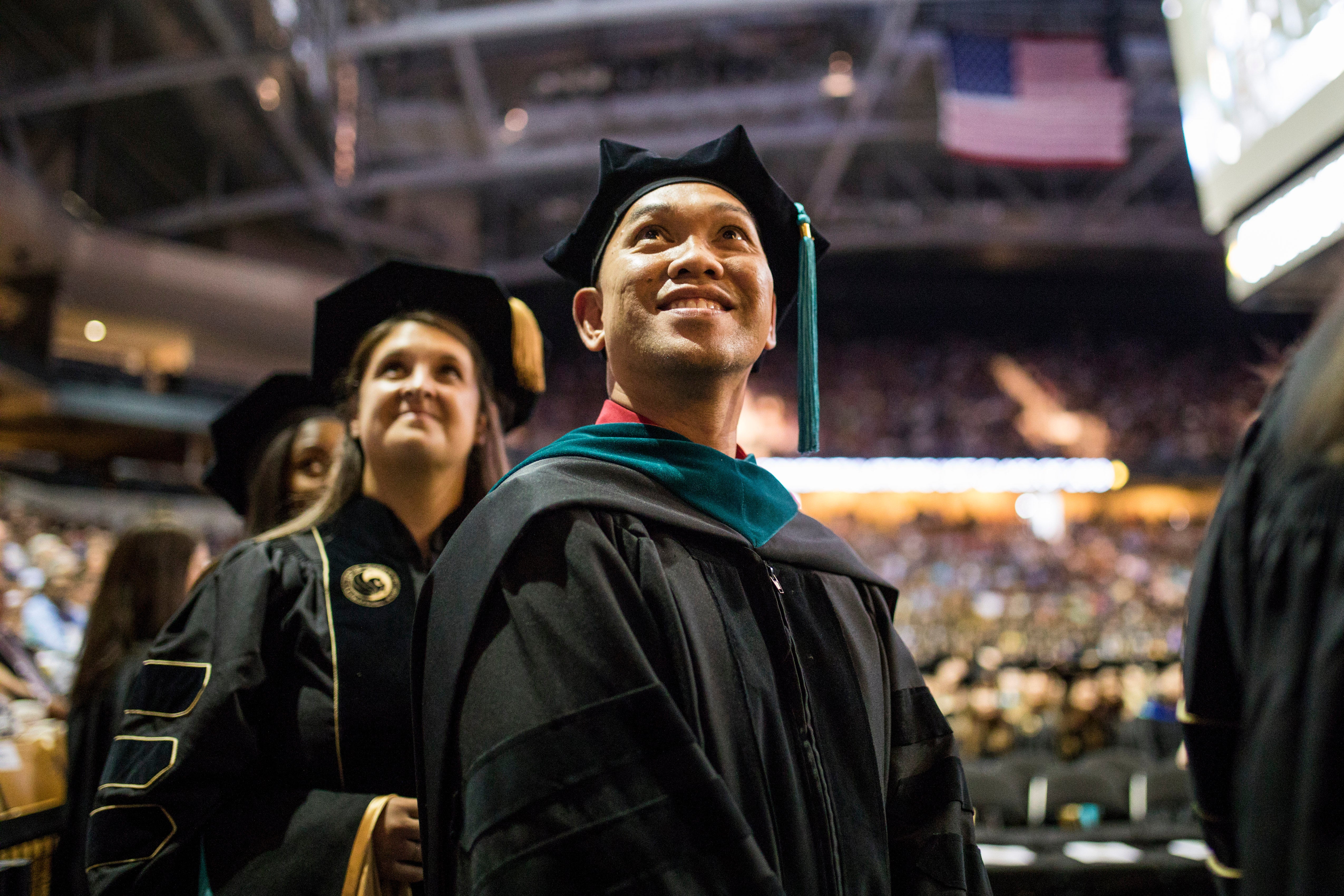 A male student looks up in awe at the crowded CFE Arena.