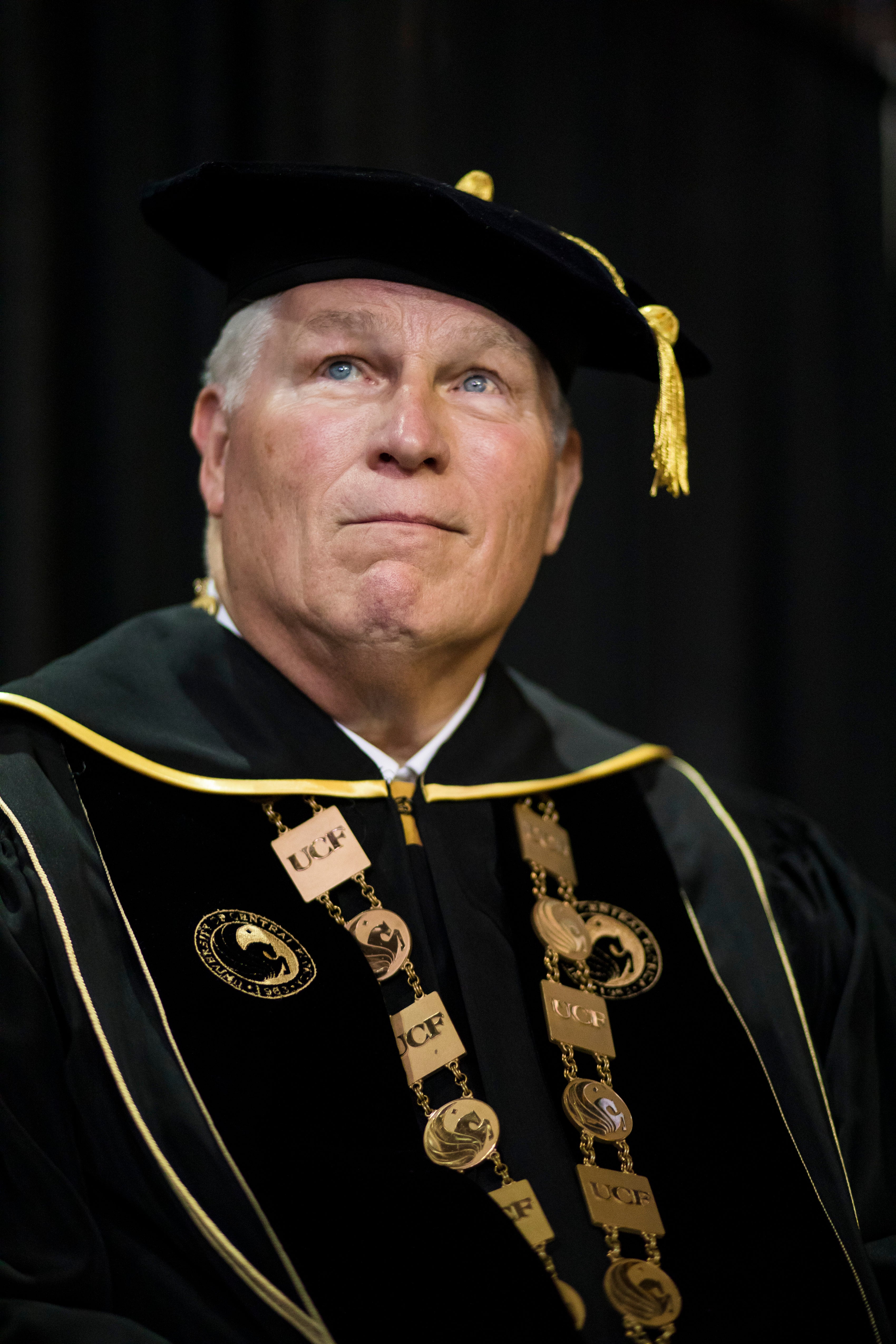 John C. Hitt looks up and off into the distance while wearing his regalia.