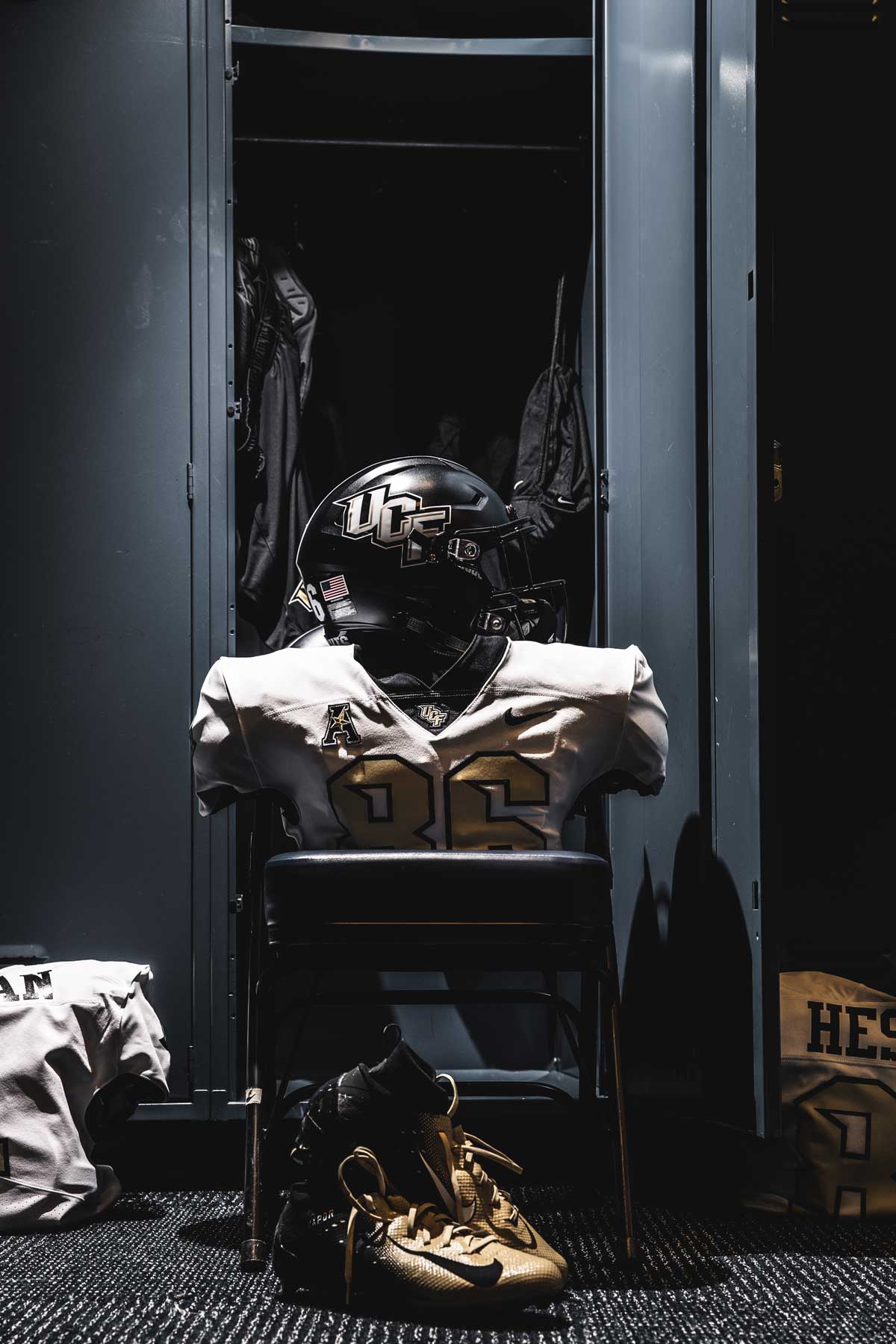 black helmet and white jersey in front of locker