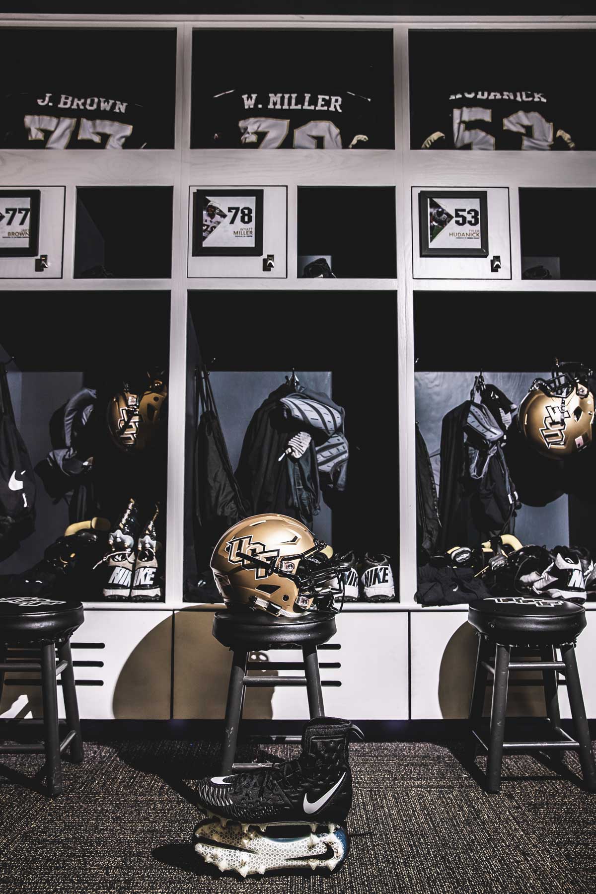 rows of lockers with a gold UCF helmet on a stool