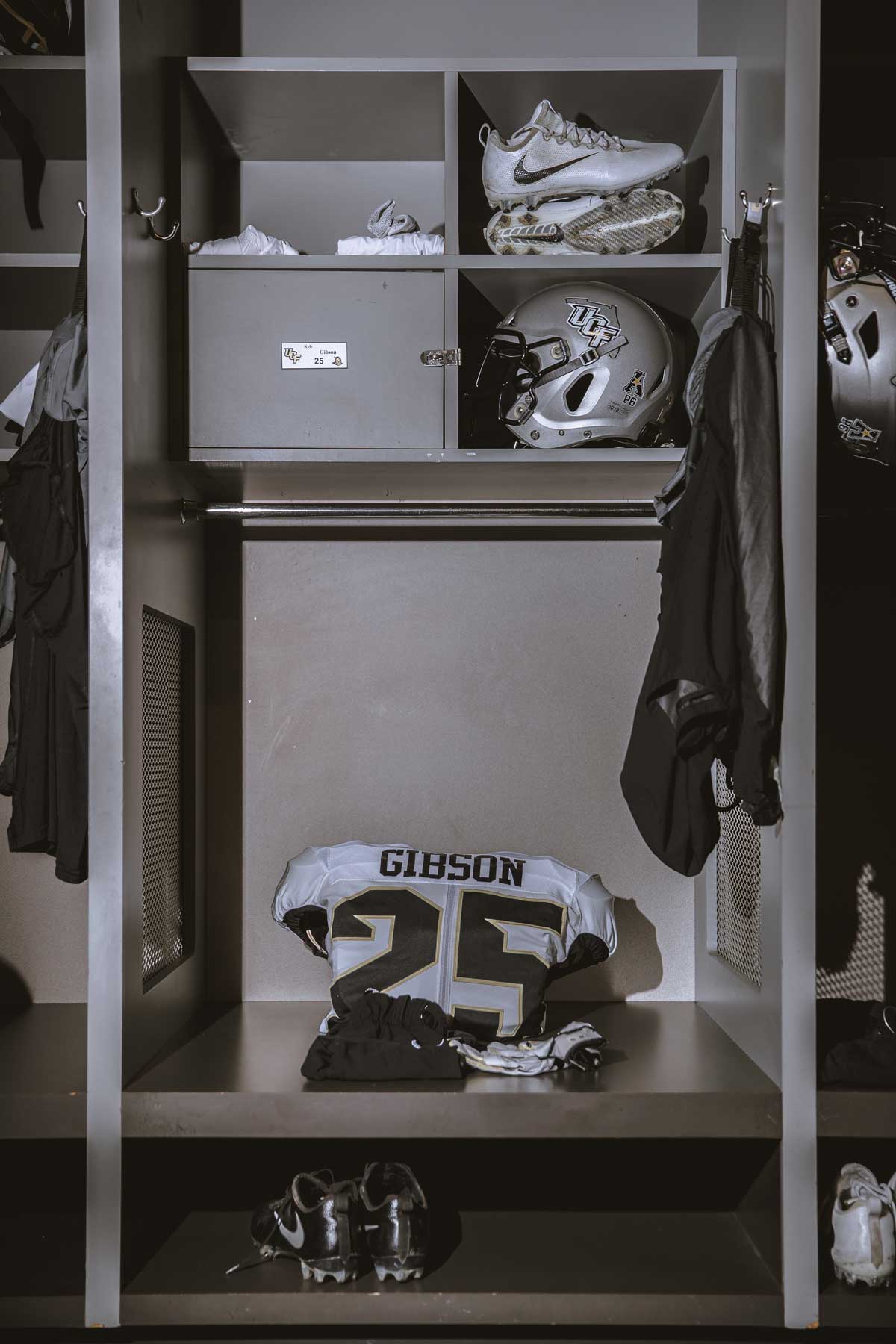single locker with white football jersey and silver helmet