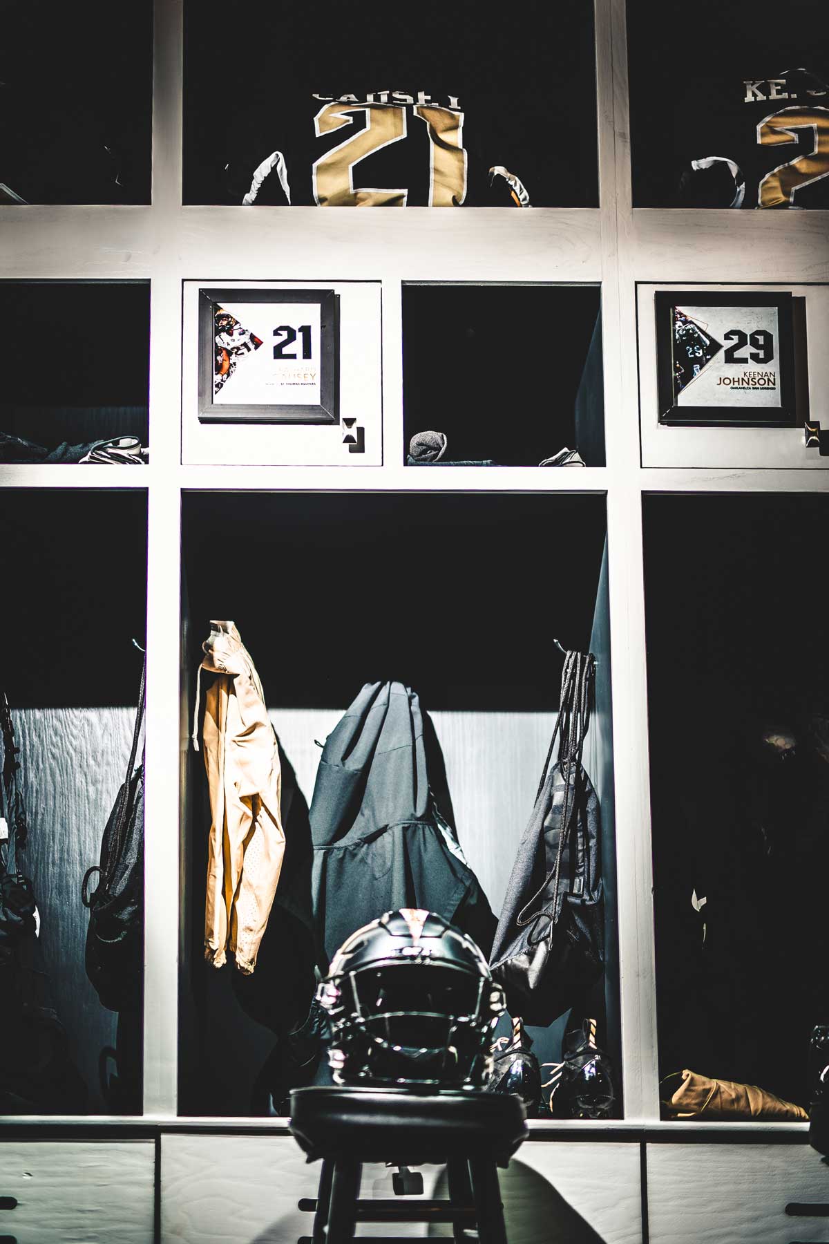 row of lockers with black helmet and jerseys