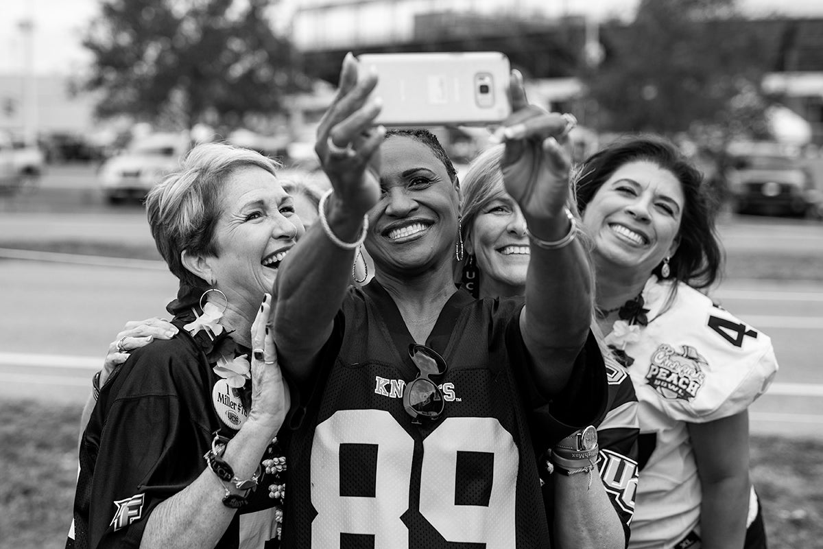 Group of ladies wearing UCF jerseys pose for selfie