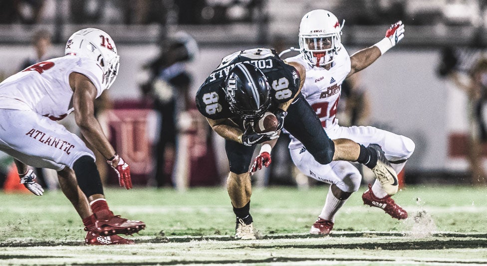 ucf tight end michael colubiale catching the football while two fau players surround him