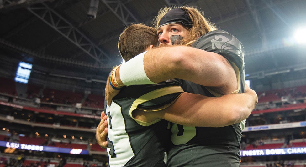 two ucf football players hug after their loss against lsu
