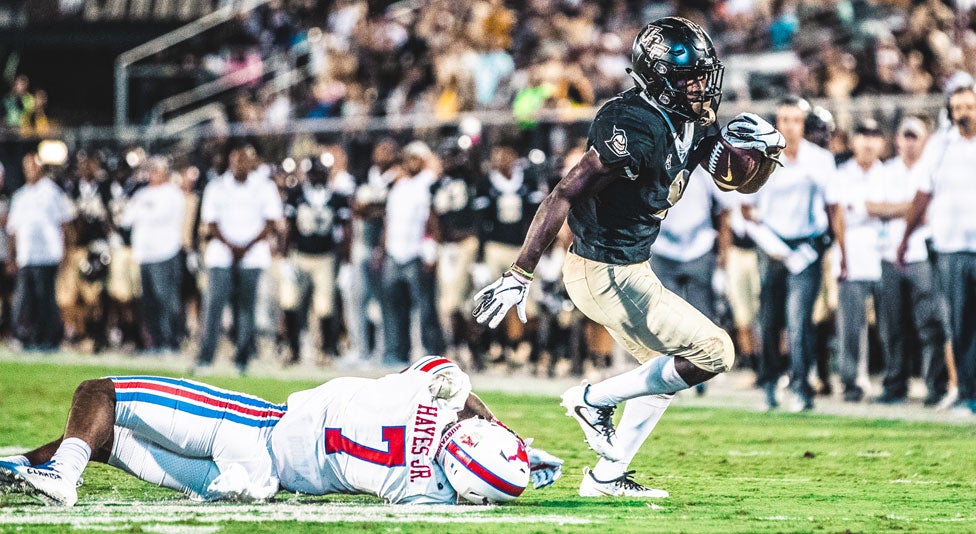 ucf running back Adrian Killins Jr. avoids a tackle from smu football player ucf running back Adrian Killins Jr. avoids a tackle from smu football player