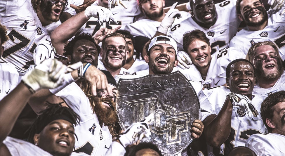 ucf knights football team celebrating their win over usf in the war on i4