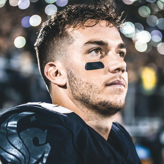 profile of ucf quarterback mckenzie milton at a football game with helmet off