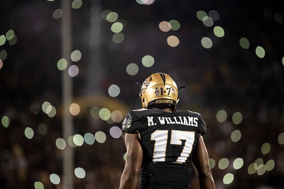 #17 football player looks at gold lights in crowd.