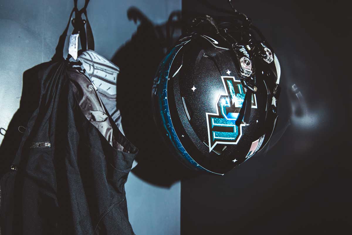 black helmet with blue UCF lettering and a blue stripe down the middle hangs in a locker