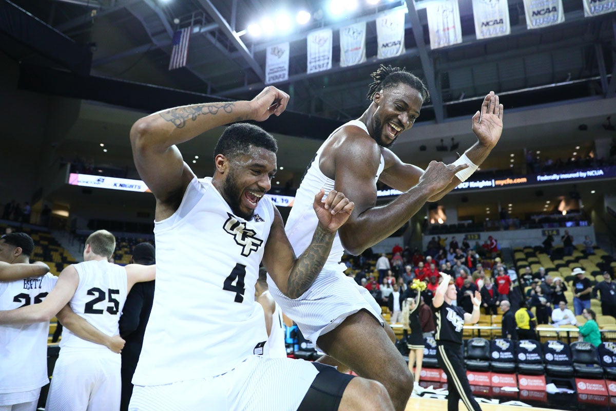 Two UCF basketball players celebrate.