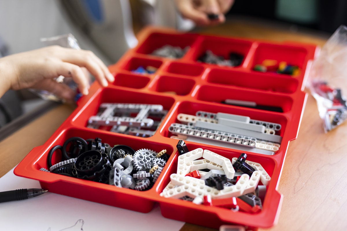 An open container of black, white and grey LEGO pieces.