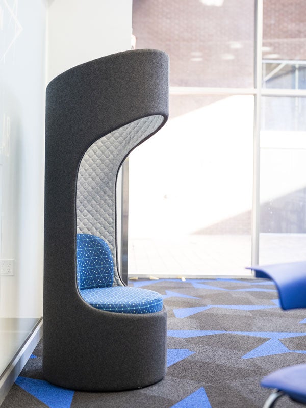 A tall grey chair with a blue seat.