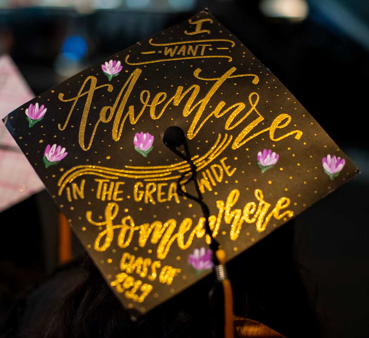 black graduation cap with gold lettering design: I want adventure in the great wide somewhere