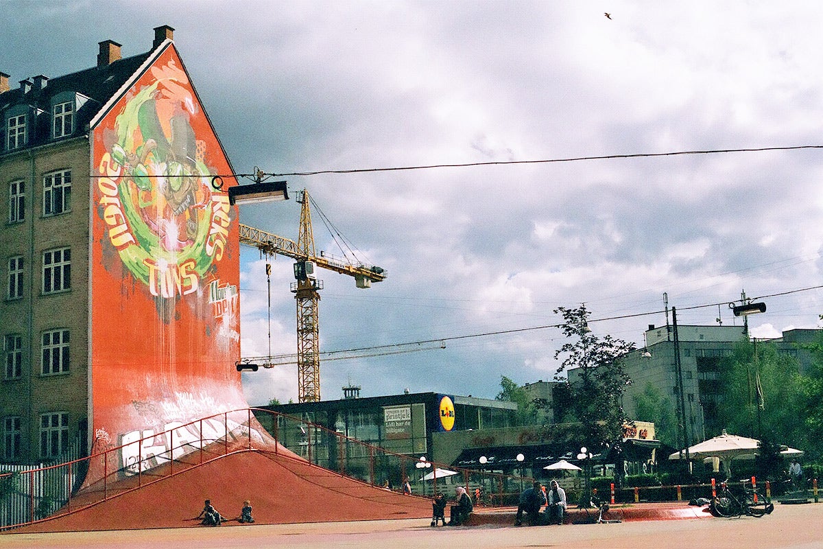 A red vertical wall which people can skate and bike off of.