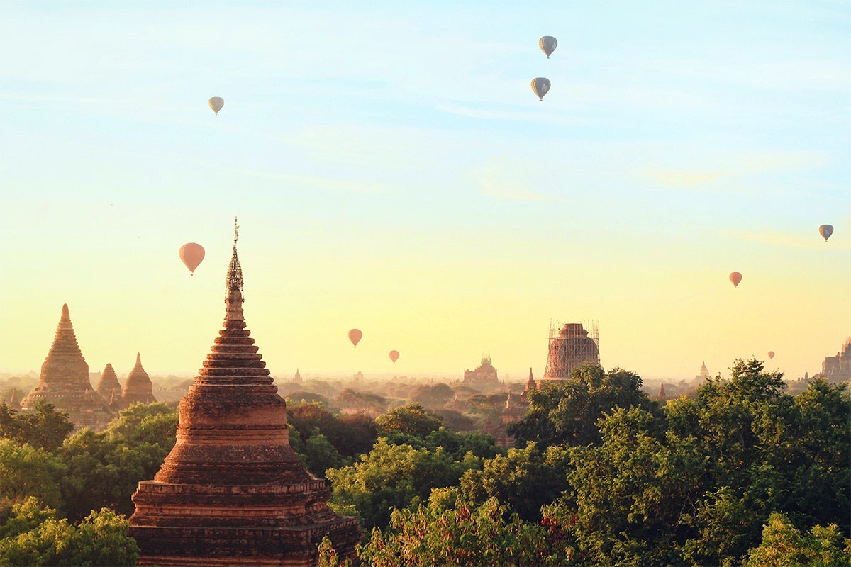 Hot air balloons in the ai during a sunrise.