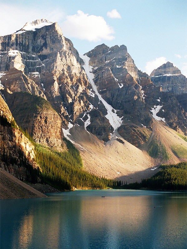 A blue lake with mountains behind it.