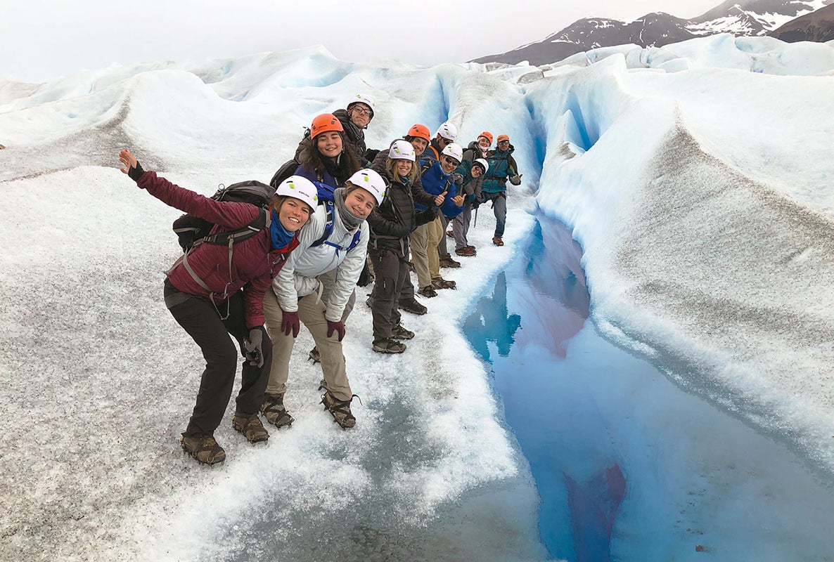 A group of people posing for a photo on a glacier.
