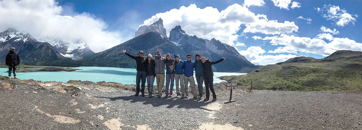 A group of people posing for a photo in front of a mountain.