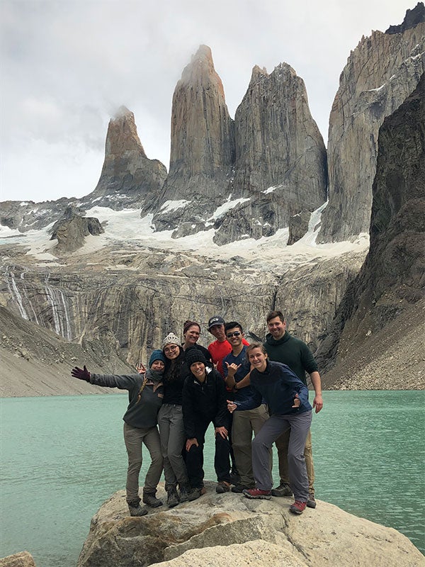 A group of people posing for a photo in front of mountains.