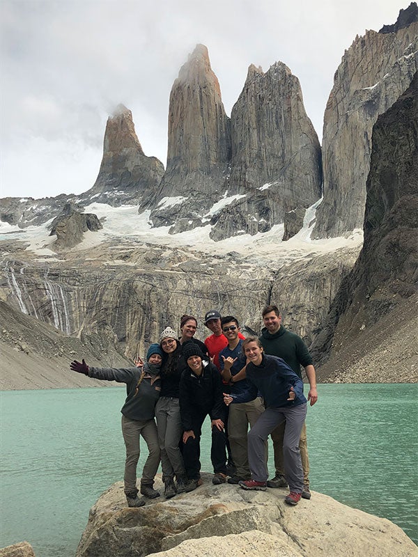 A group of people posing for a photo in front of mountains.