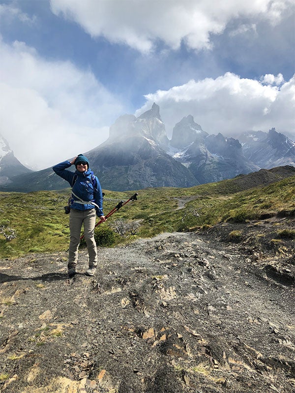 A man posing in front of a mountain.