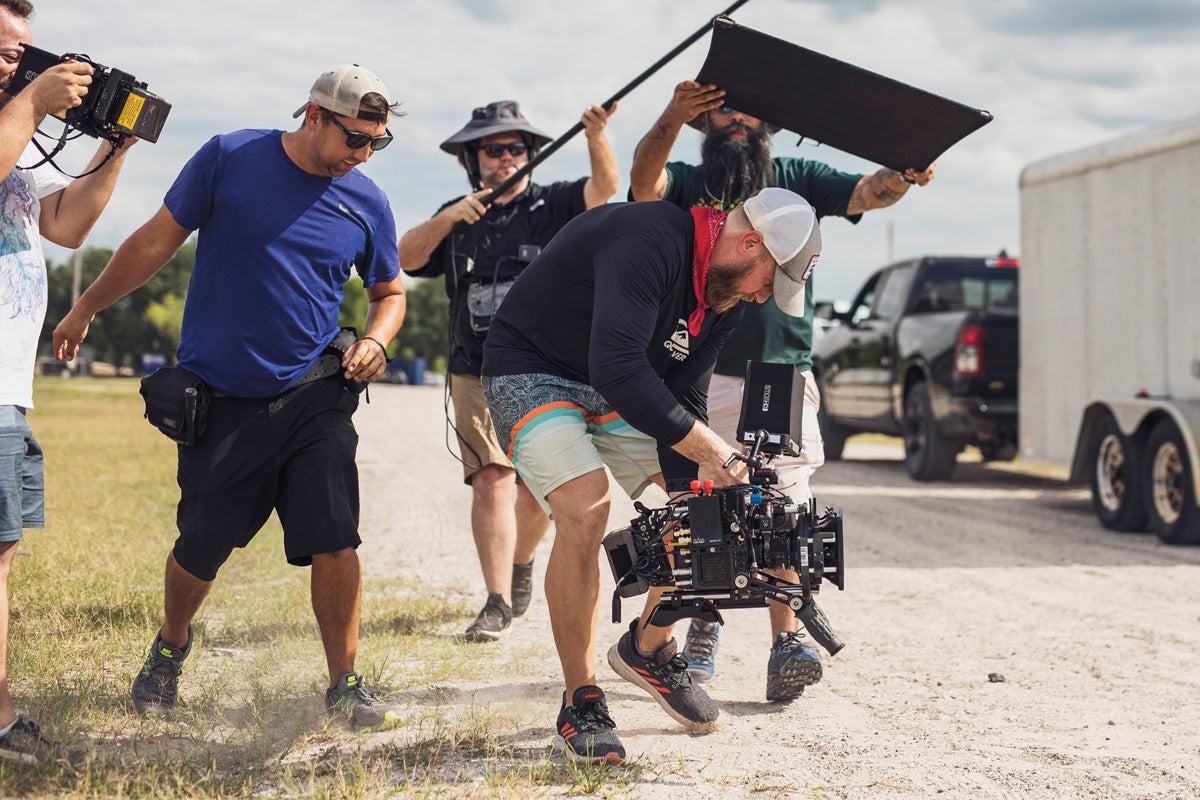 Four members of a film crew capture a shot.
